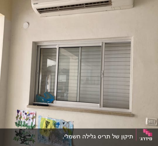 חלון עם תריסים סגורים מתחת למזגן על קיר פנימי